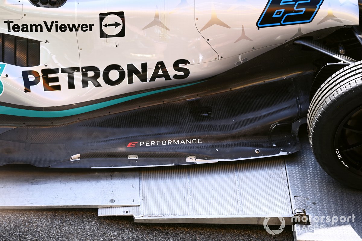 The Mercedes team unload a W13 in the pit lane