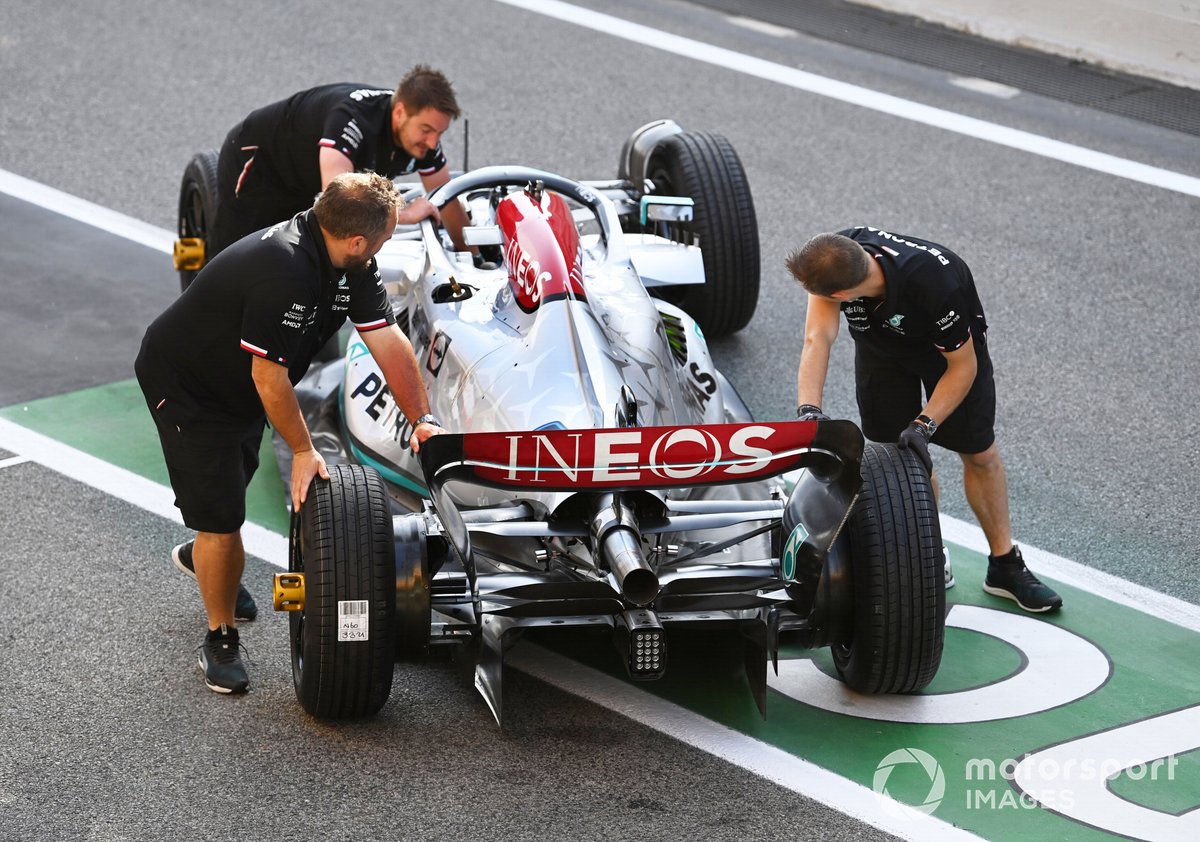 The Mercedes team unload a W13 in the pit lane