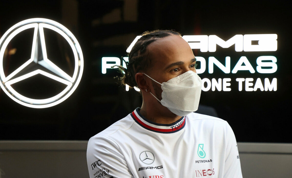 Lewis Hamilton standing in front of the Mercedes logo. Barcelona February 2022