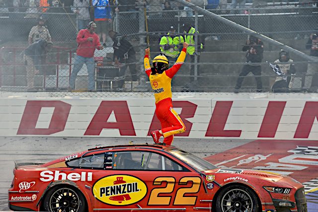 Joey Logano stands on his car NKP