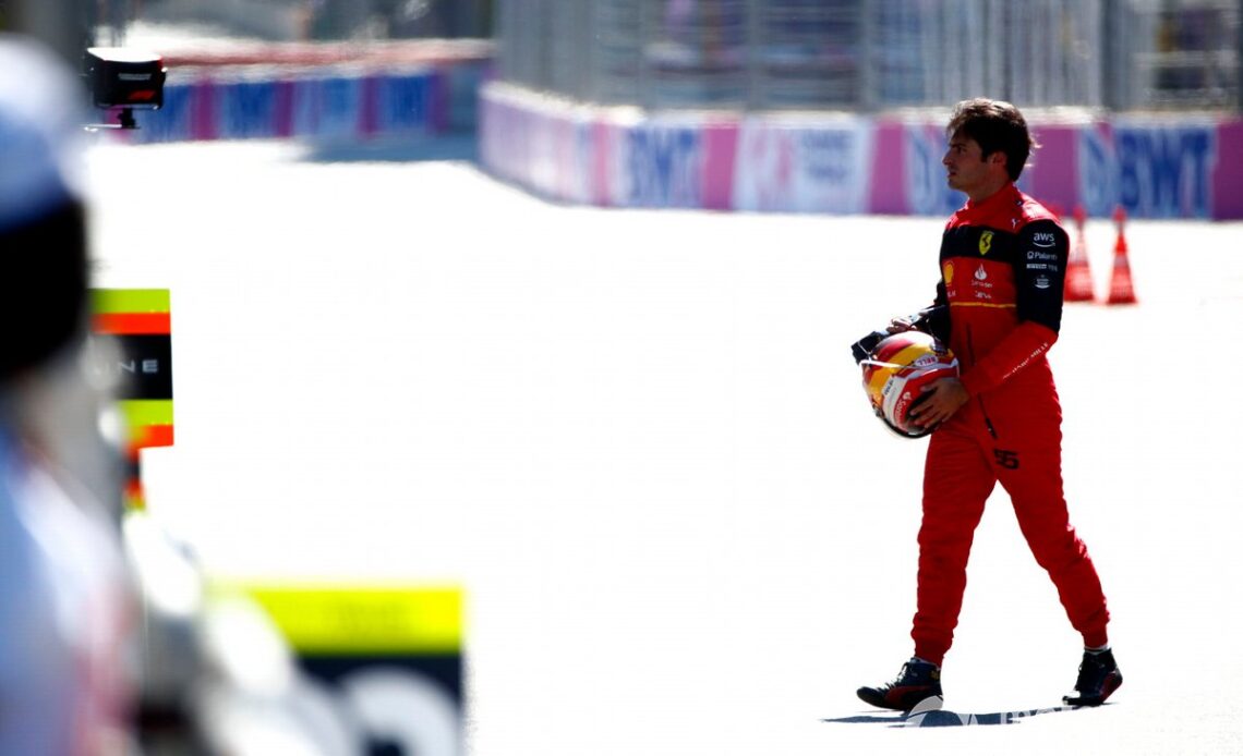 Carlos Sainz walks back to his garage after retiring from the race