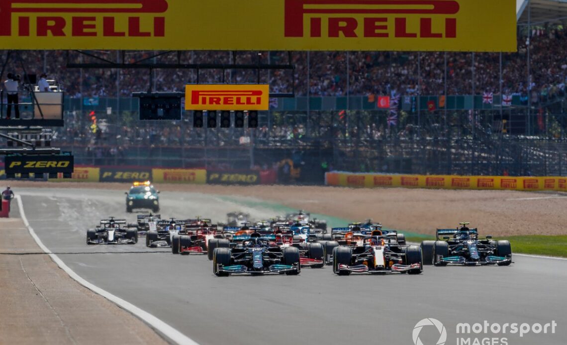 Max Verstappen, Red Bull Racing RB16B, and Lewis Hamilton, Mercedes W12, lead the field away at the start