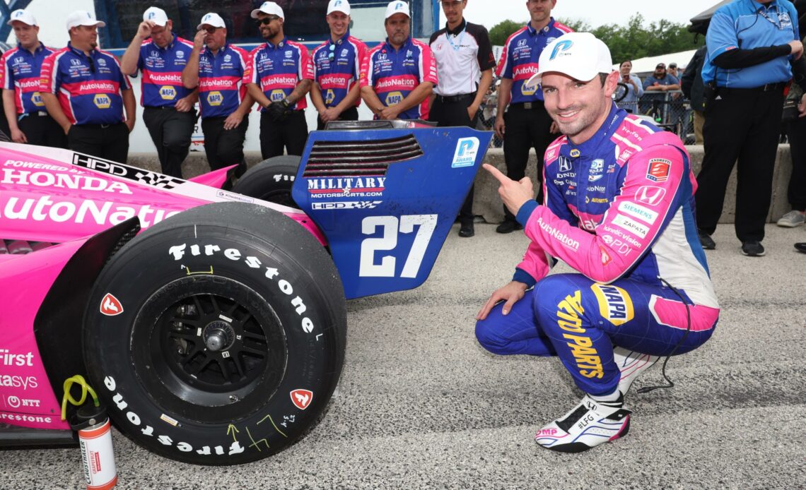 Alexander Rossi pointing to The Sticker after winning pole for Road America in 2022