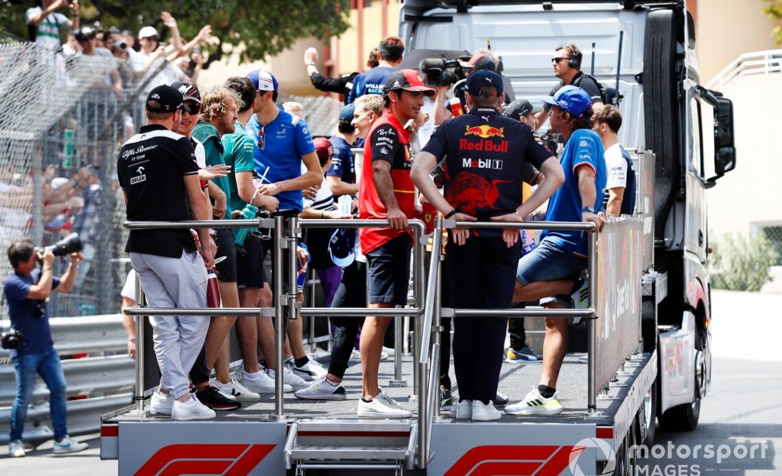 Carlos Sainz, Ferrari, speaks with Max Verstappen, Red Bull Racing, on the drivers parade bus