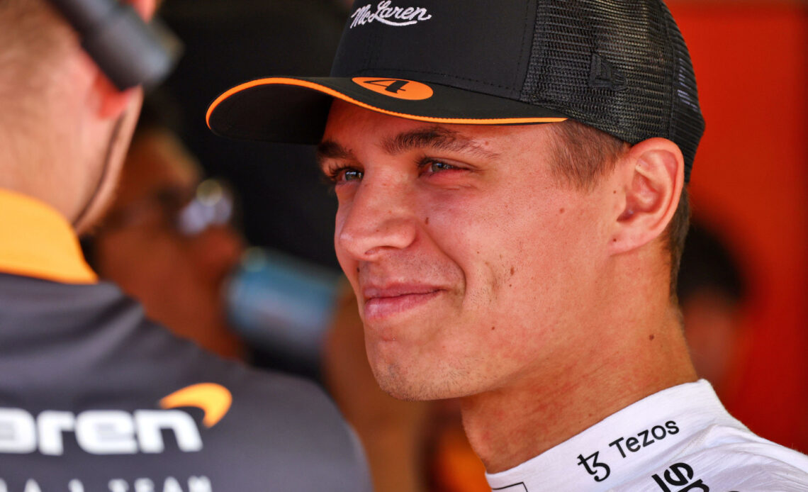 Lando Norris smiling as he speaks with his McLaren team. Monaco May 2022