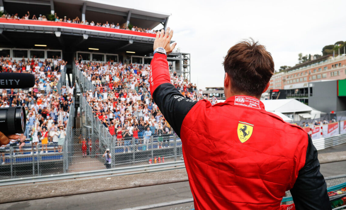 Charles Leclerc with his back to the camera as he waves to the crowd. Monaco May 2022