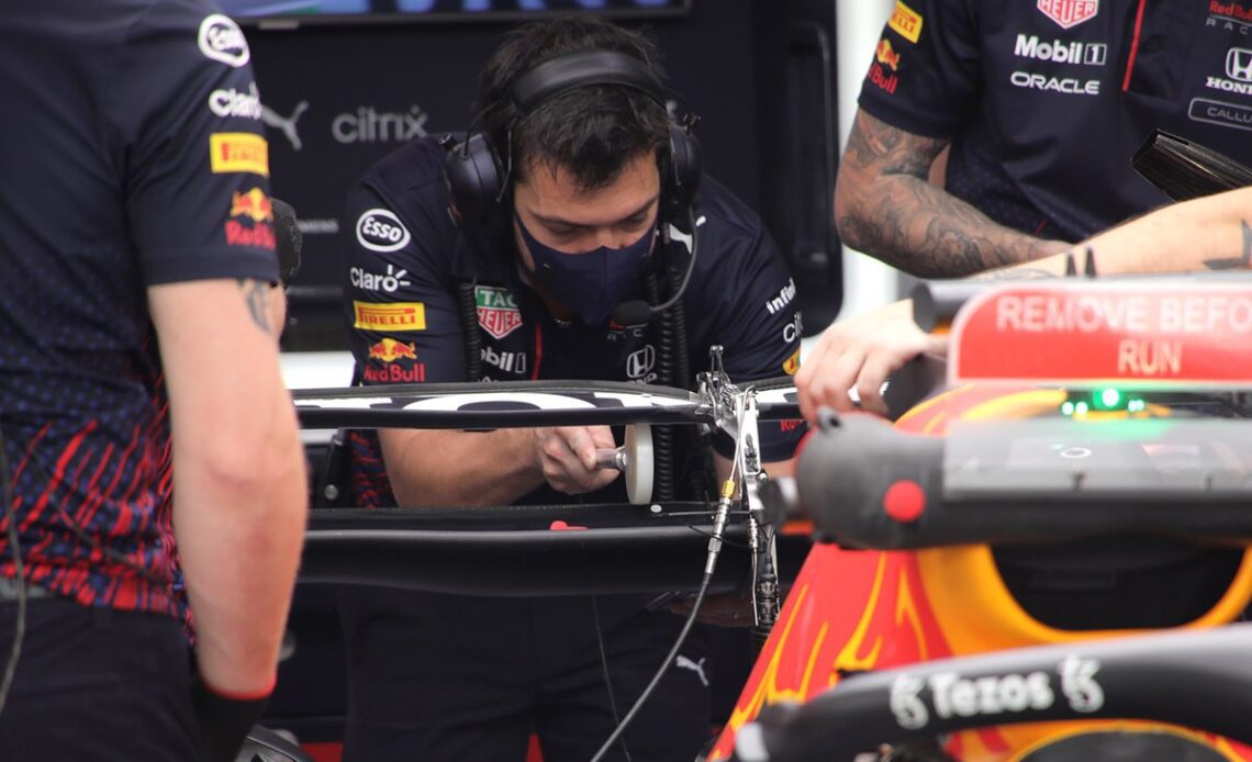 Red Bull Racing members check the RB16B rear wing