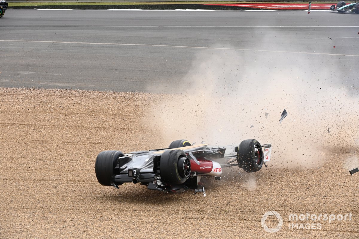 Zhou Guanyu, Alfa Romeo C42, slides across the gravel during a crash at the start