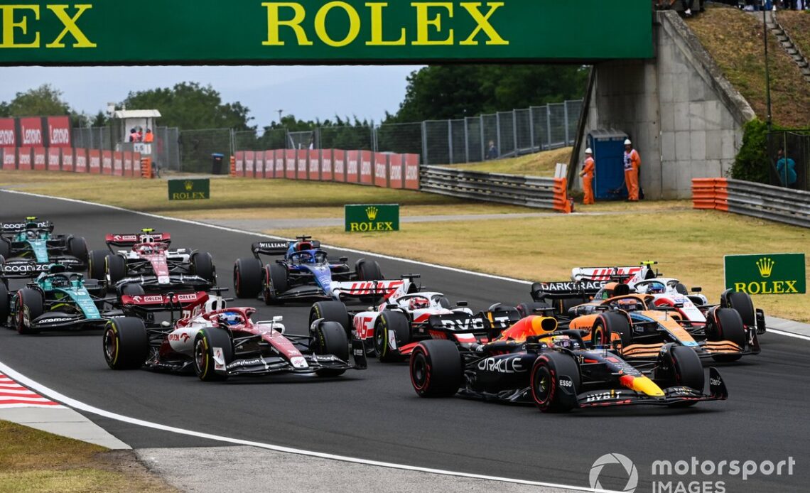 Max Verstappen, Red Bull Racing RB18, Daniel Ricciardo, McLaren MCL36, Mick Schumacher, Haas VF-22, Kevin Magnussen, Haas VF-22, Valtteri Bottas, Alfa Romeo C42, the remainder of the field on the opening lap