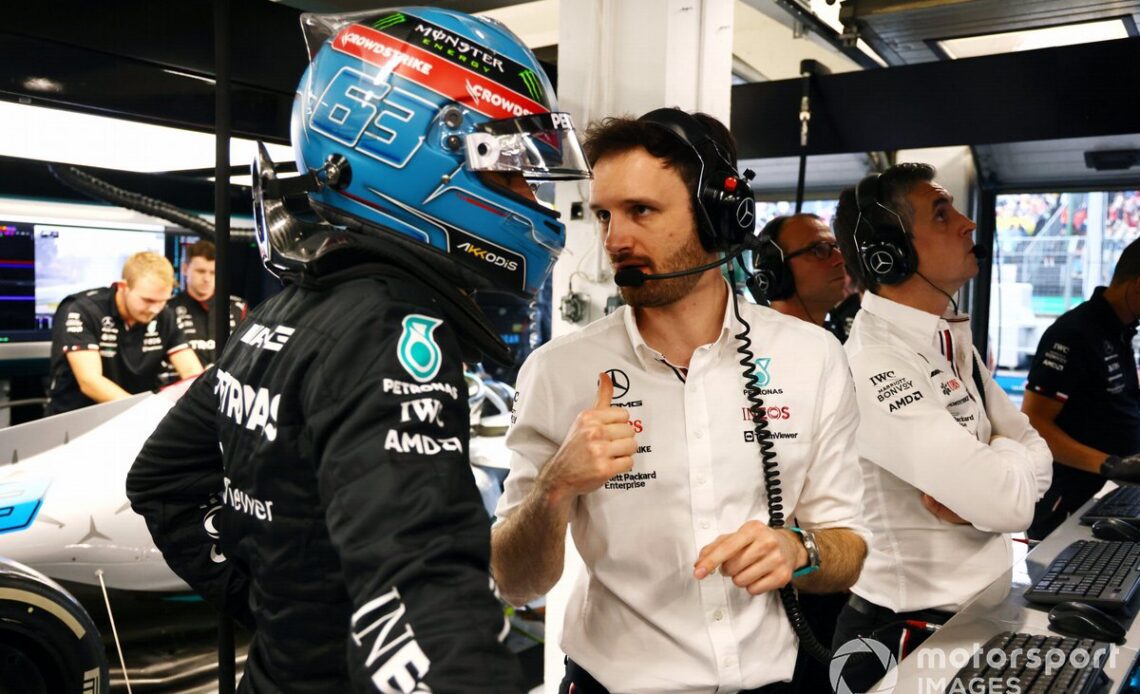 George Russell, Mercedes-AMG, talks to a colleague in the team's garage