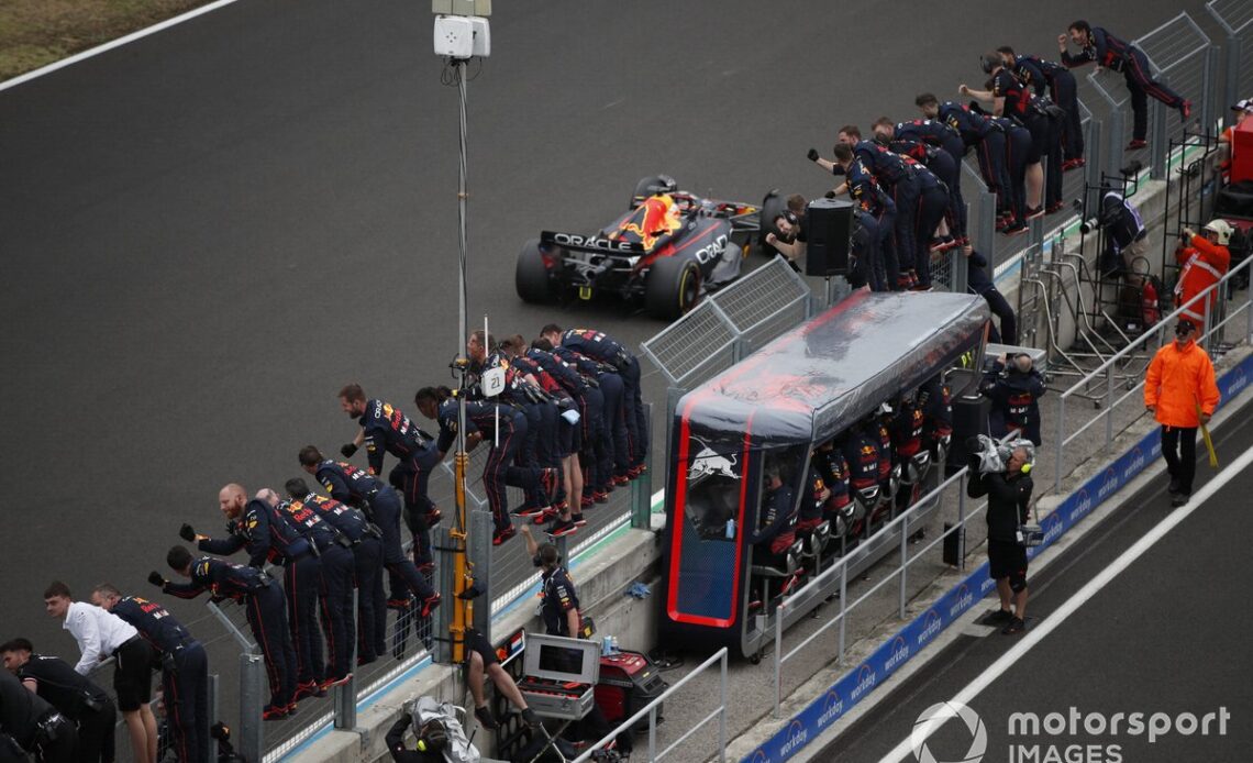 Max Verstappen, Red Bull Racing RB18, 1st position, takes the chequered flag to the delight of his team on the pit wall