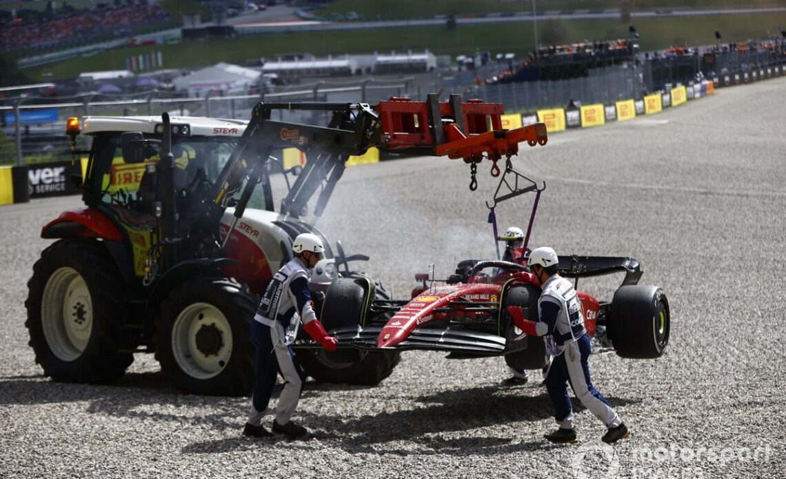 Marshals remove the fire damaged car of Carlos Sainz, Ferrari F1-75, from the circuit