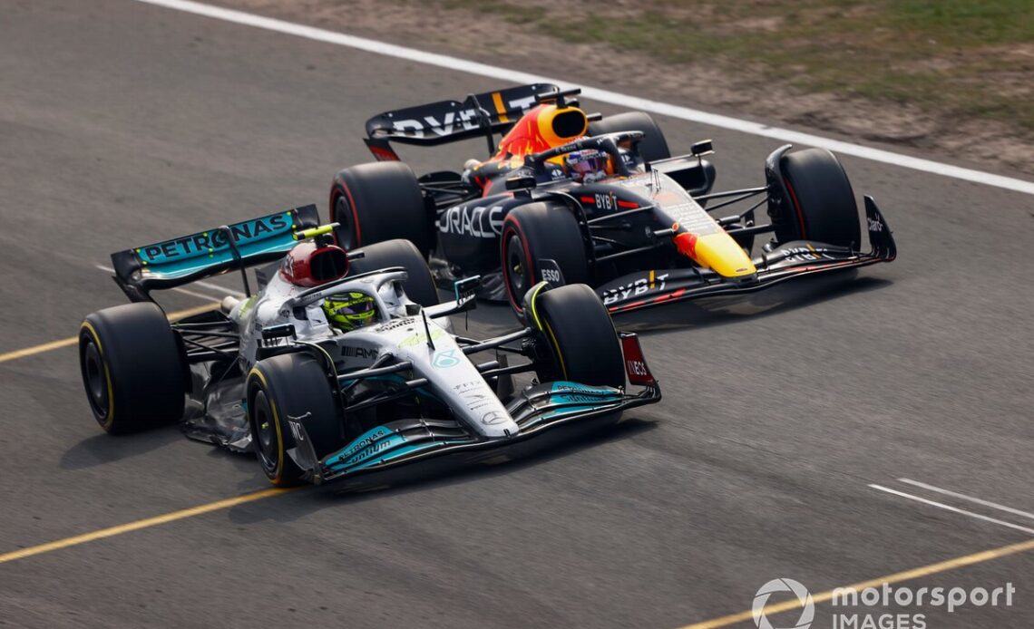 Lewis Hamilton, Mercedes W13, battles with Max Verstappen, Red Bull Racing RB18, for the lead after the restart
