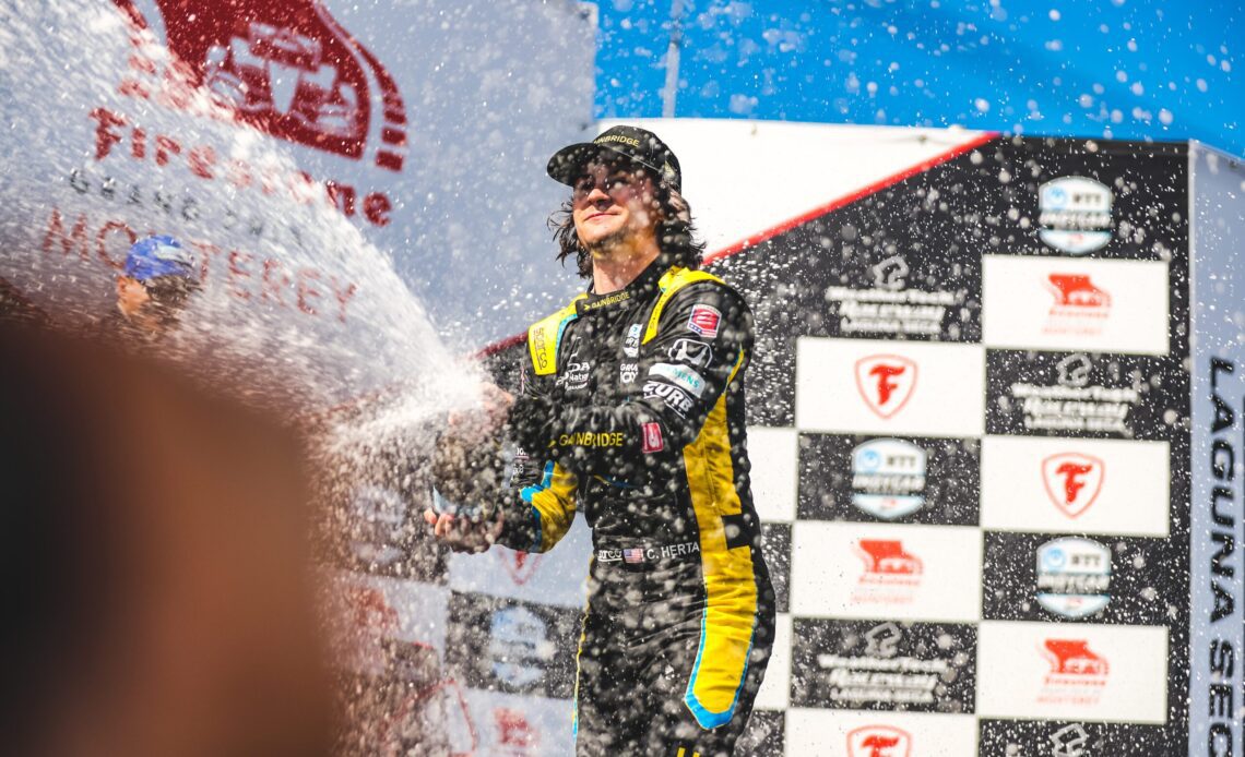 Colton Herta spraying champagne after winning the 2021 Firestone Grand Prix of Monterey