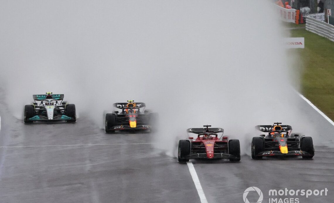 Max Verstappen, Red Bull Racing RB18, battles with Charles Leclerc, Ferrari F1-75, ahead of Sergio Perez, Red Bull Racing RB18, Lewis Hamilton, Mercedes W13, the rest of the field at the start