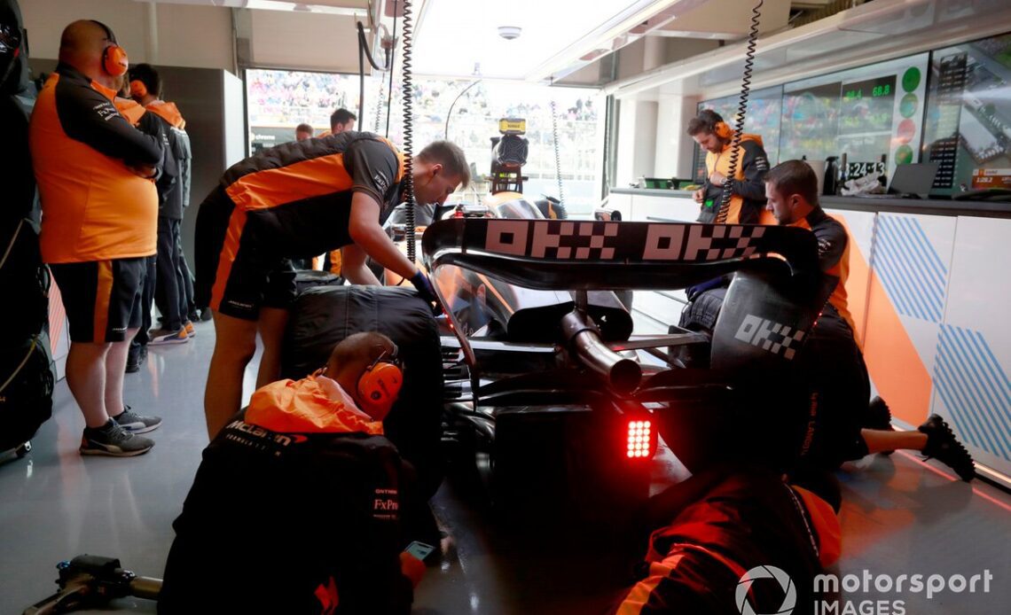 Mechanics work on the car of Lando Norris, McLaren MCL36, in the garage
