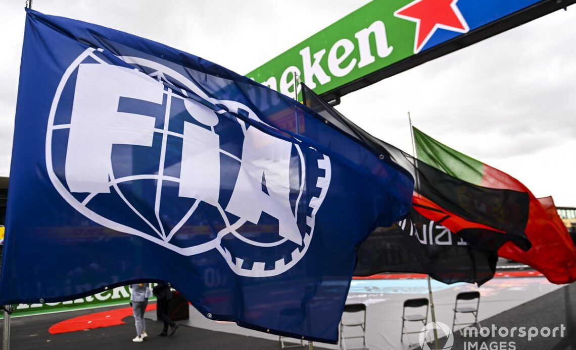 A huge FIA flag flies on the grid