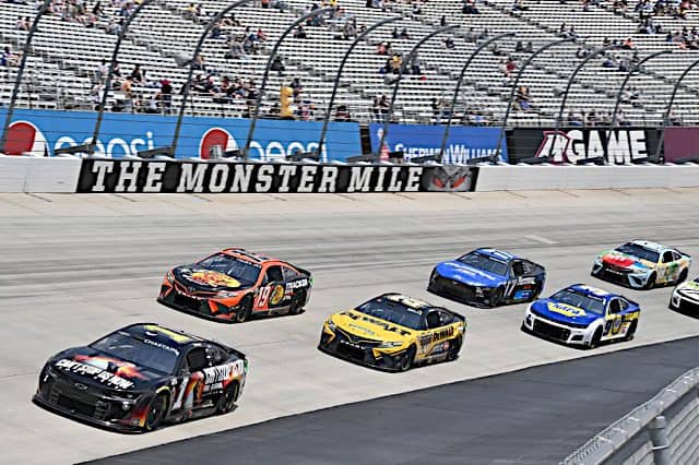 NASCAR Cup Series cars of Ross Chastain and Martin Truex Jr. pack racing at Dover Motor Speedway, NKP