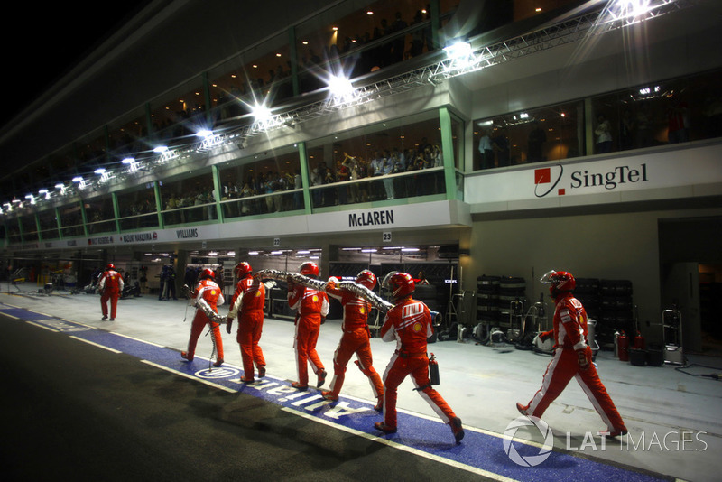 The Ferrari pit crew return with the broken fuel hose of Felipe Massa, Ferrari F2008