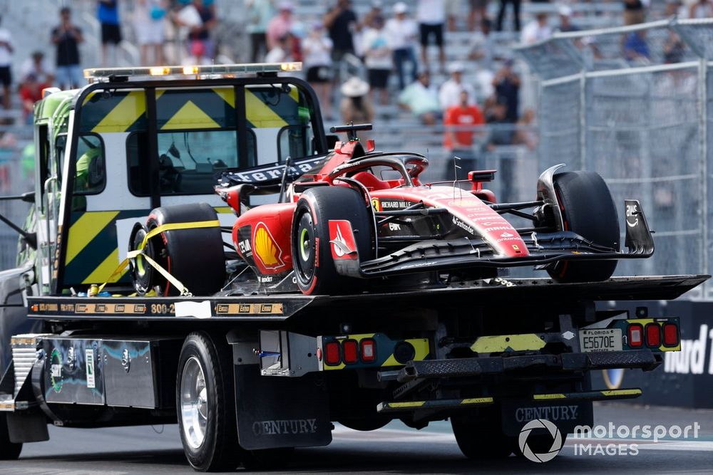 The crash damaged Charles Leclerc Ferrari SF-23 is returned to the pits on the back of a truck