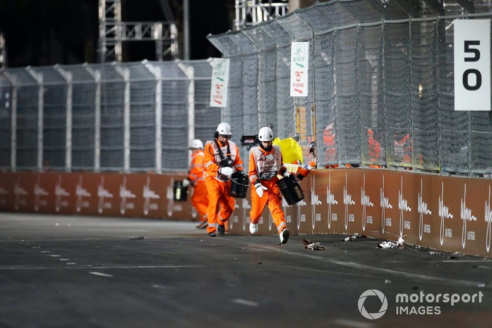 Marshals remove debris from the circuit after a crash for Lando Norris, McLaren MCL60