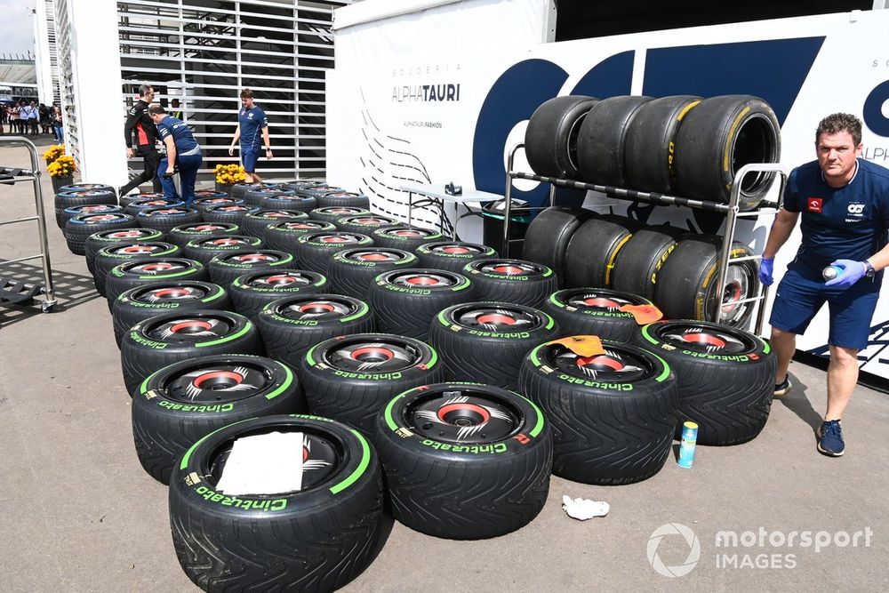 AlphaTauri team members work on Pirelli tyres in the paddock