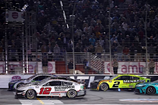 Nascar Cup Series cars of Daniel Suarez, Kyle Busch (hidden) and Ryan Blaney going three-wide at the finish line, pack racing, NKP