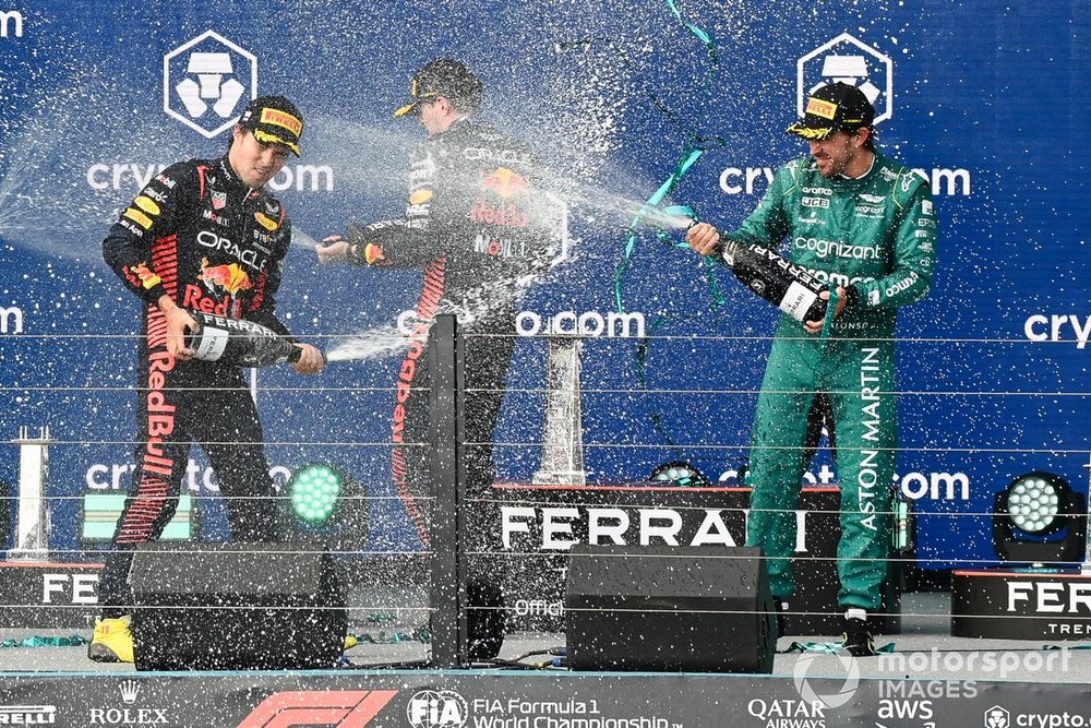 The Red Bull trophy delegate, Sergio Perez, Red Bull Racing, 2nd position, Max Verstappen, Red Bull Racing, 1st position, Fernando Alonso, Aston Martin F1 Team, 3rd position, spray Champagne on the podium