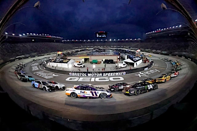 NASCAR Cup Series cars of Denny Hamlin, Ty Gibbs and the field pack racing in Bass Pro Shops Night Race at Bristol Motor Speedway, NKP