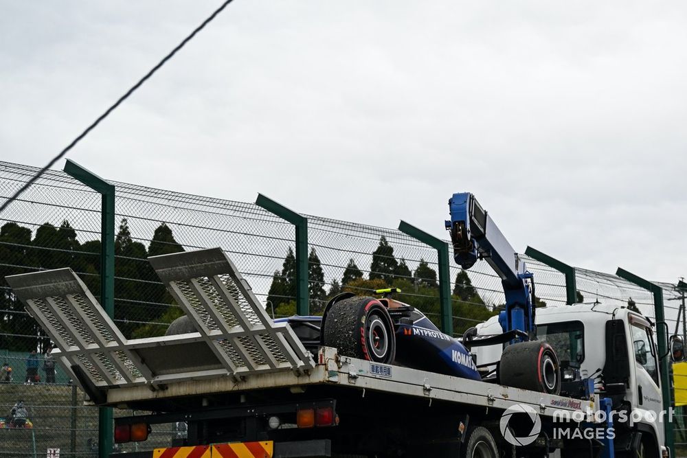 Marshals return the damaged car of Logan Sargeant, Williams FW46, to the pits after a crash in FP1