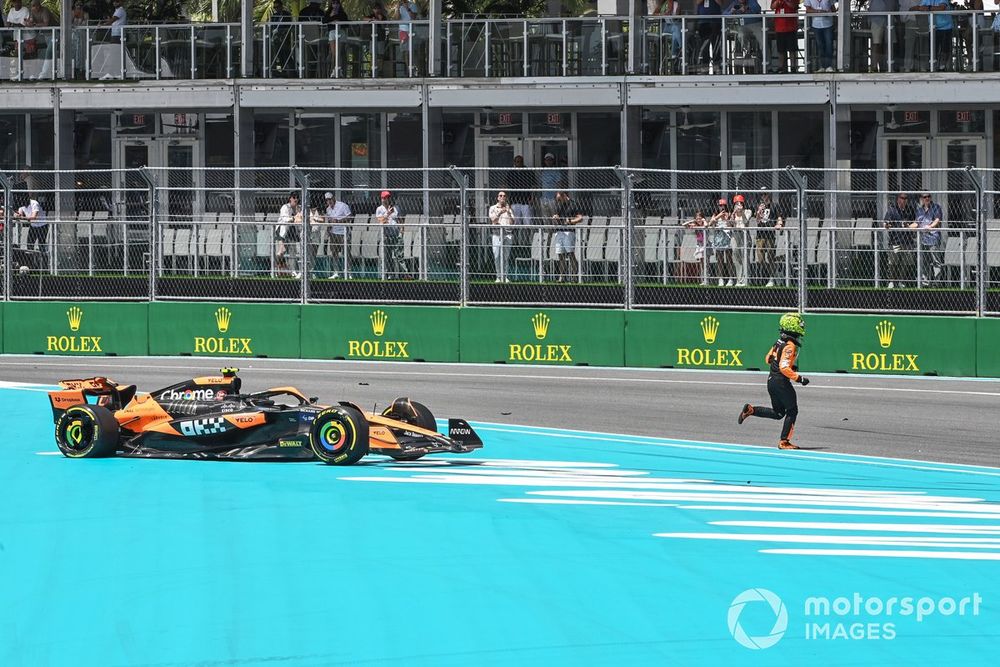 Lando Norris, McLaren MCL38, crosses the track on foot after a crash on the opening lap