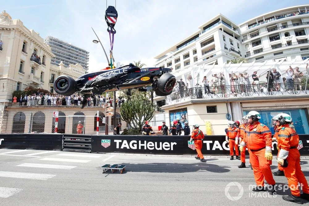 Marshals remove the damaged car of Sergio Perez after the opening lap crash