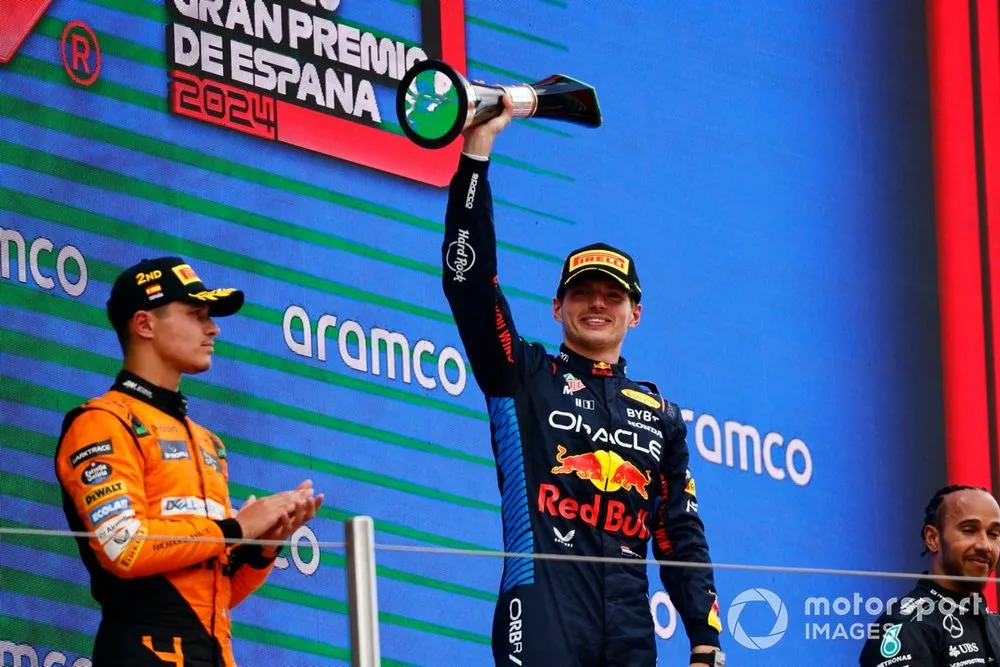 Max Verstappen, Red Bull Racing, 1st position, lifts the winners trophy on the podium alongside Lando Norris, McLaren F1 Team, 2nd position