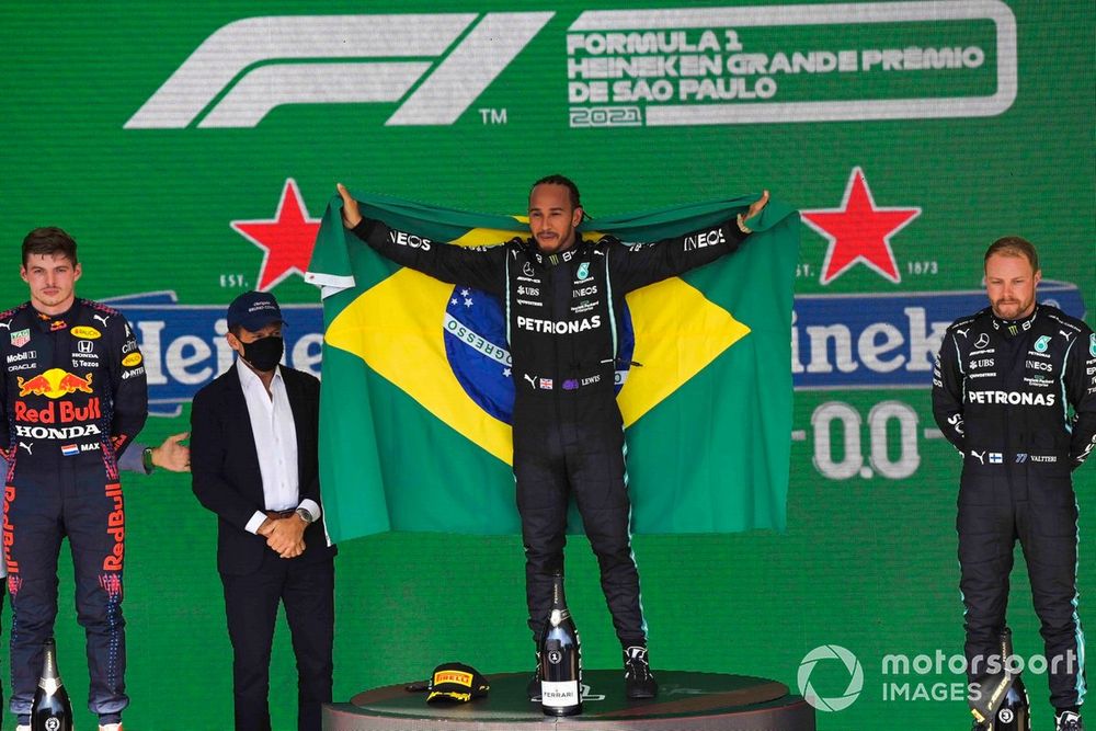 Lewis Hamilton, Mercedes, 1st position, celebrates with a Brazilian flag on the podium